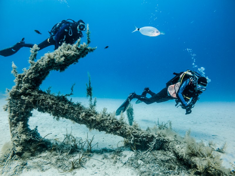 Divers near anchor at Cirkewwa Marine Park, Malta.